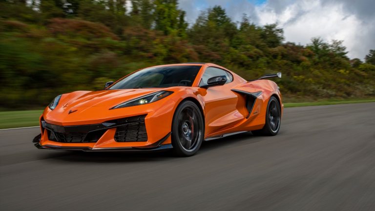 an orange sports car driving down a road.