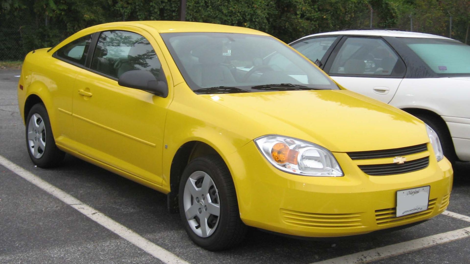 a yellow car is parked in a parking lot.