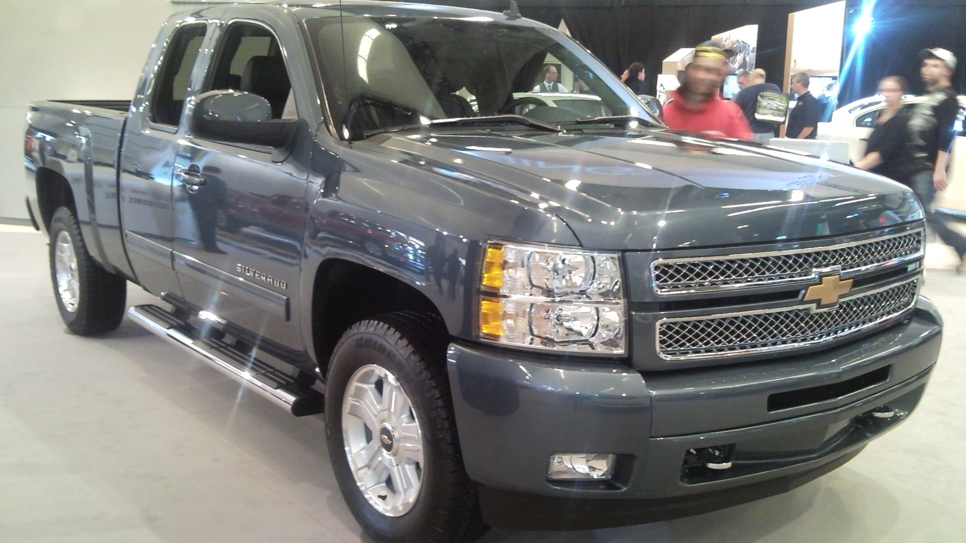 a silver truck is on display at a show.