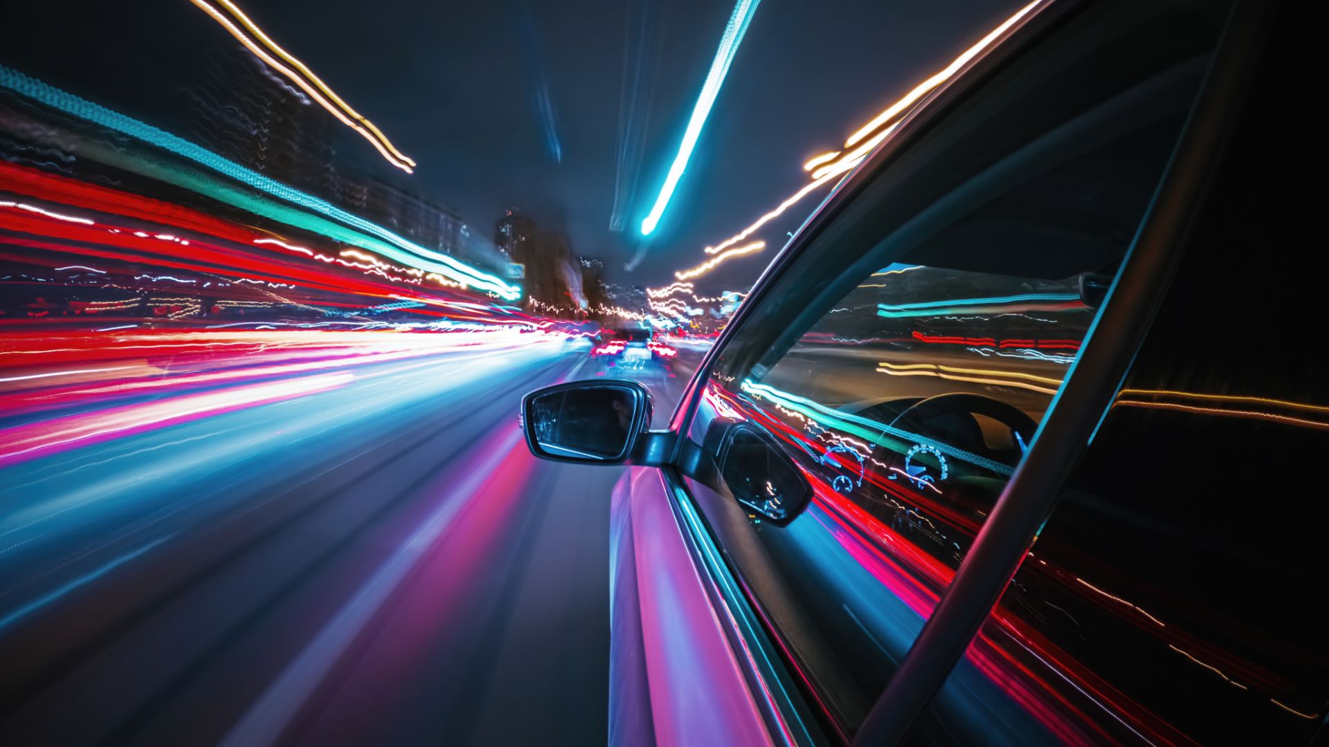 a car driving down a city street at night.