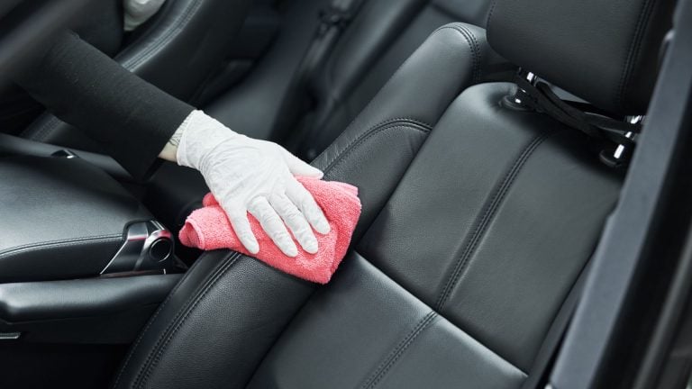 a person cleaning a car with a micro cloth.