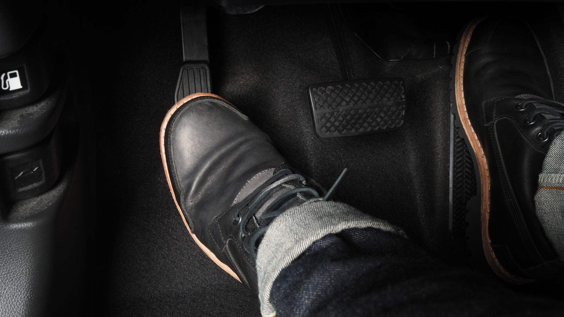 a person's feet in a pair of black shoes.