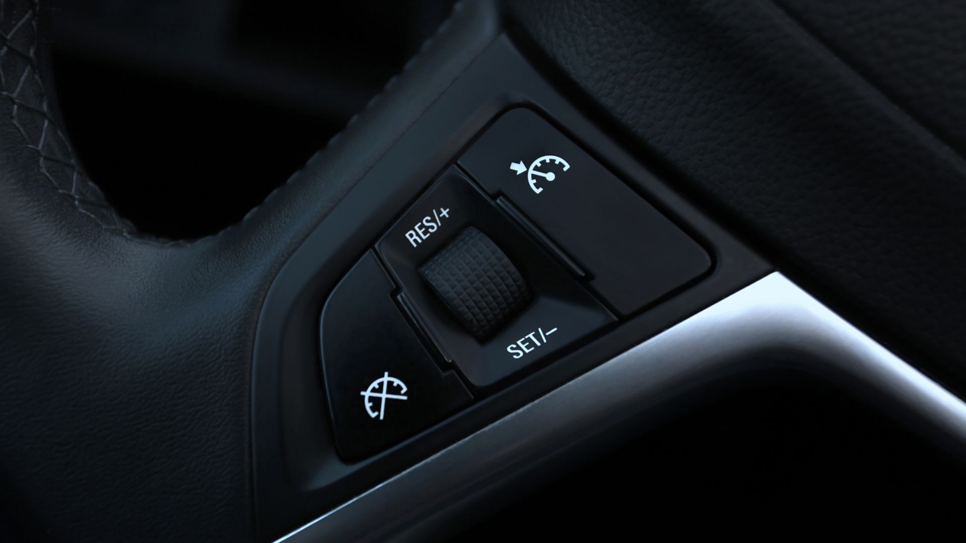 a close up of a steering wheel and buttons on a car.