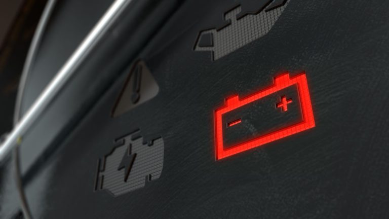 a close up of a car dashboard with a red light.