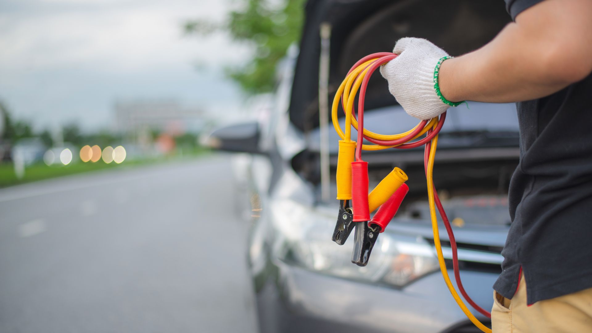 a man is holding a jump rope in front of a car.