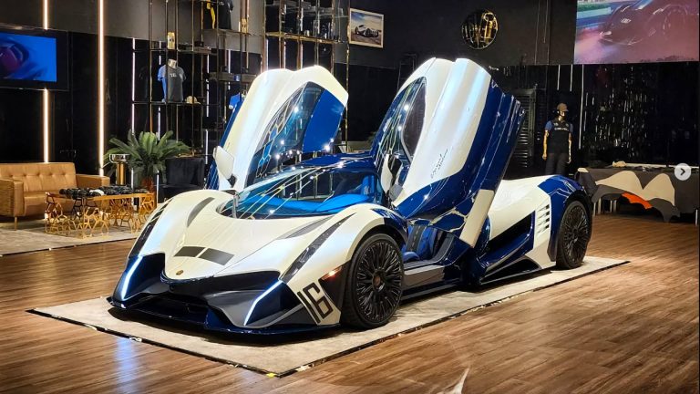 a blue and white car on display in a showroom.