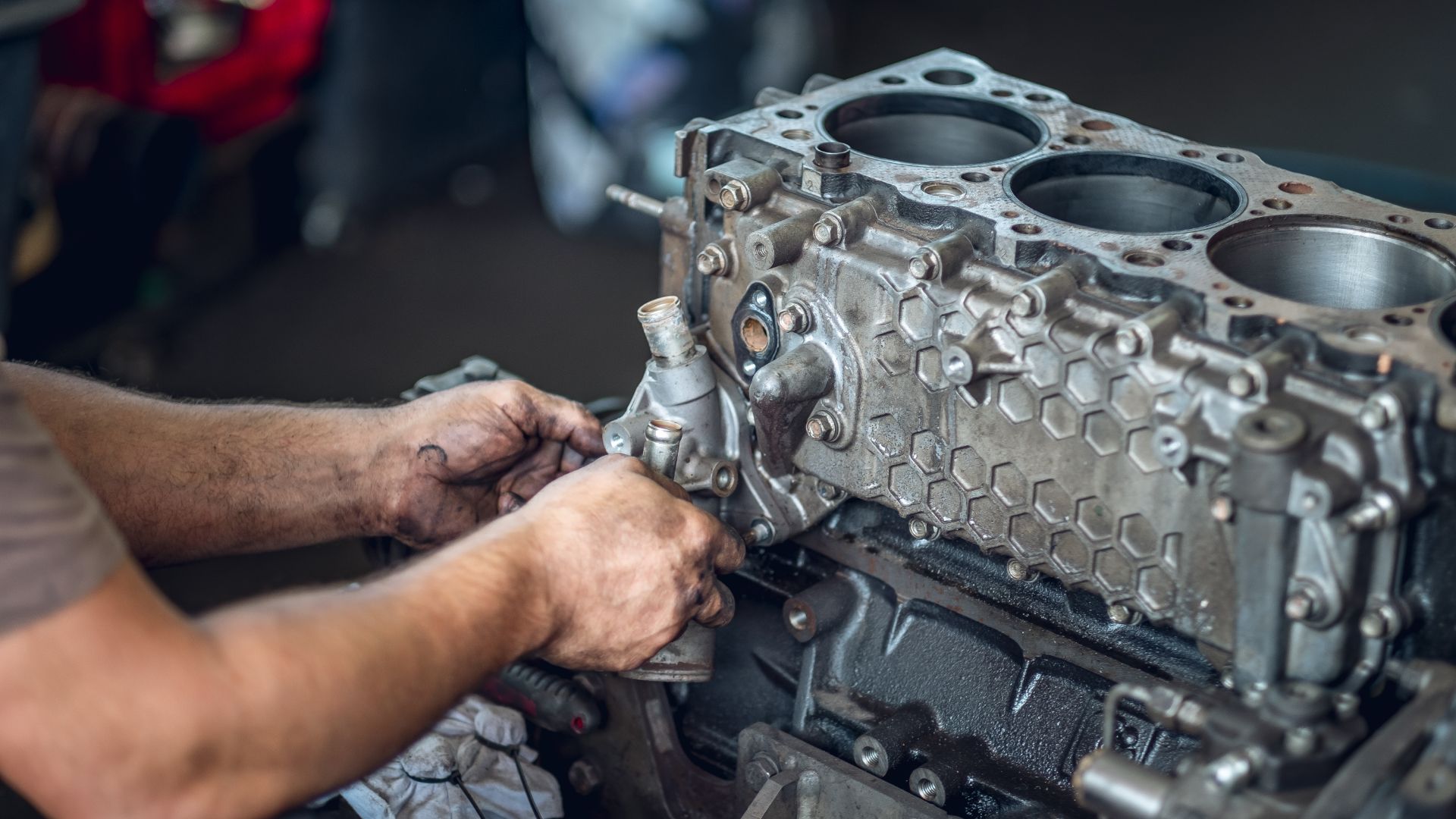 a man working on an engine in a garage.