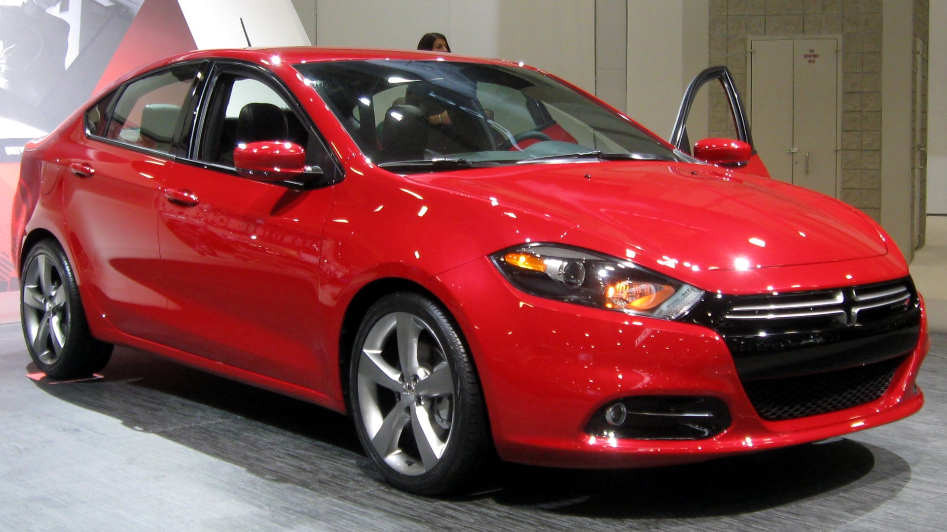 a red car is on display at a show.