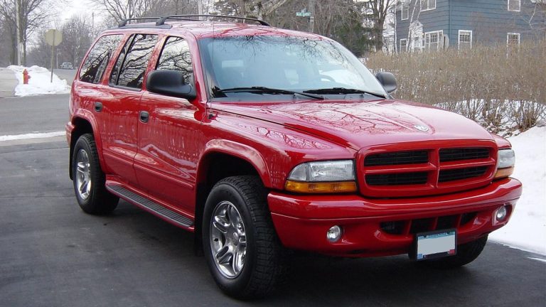 a red suv parked on the side of the road.