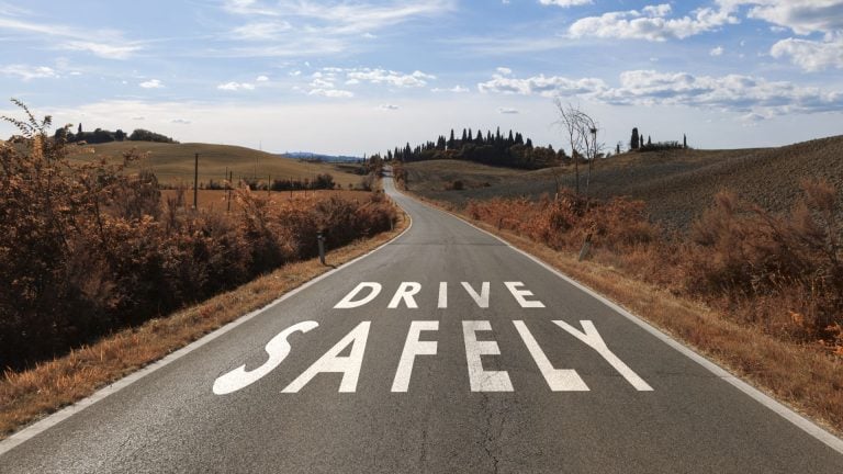 an empty road with a drive safely painted on it.