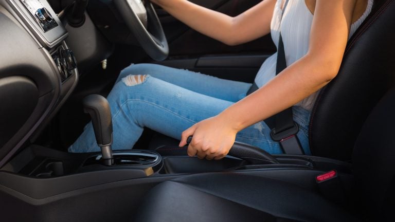 a woman sitting in a car holding a steering wheel.