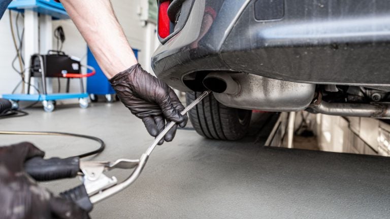 a man working on a car in a garage.