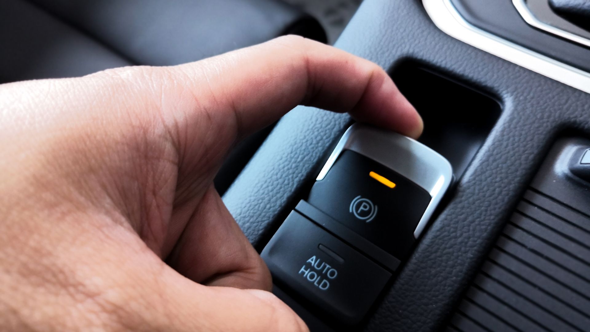 a hand is pressing a button on a car.