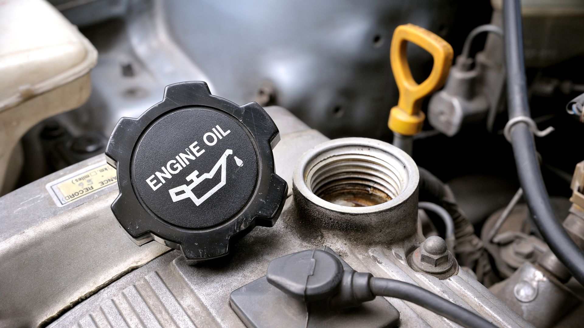 an engine oil cap with a wrench on top of it.