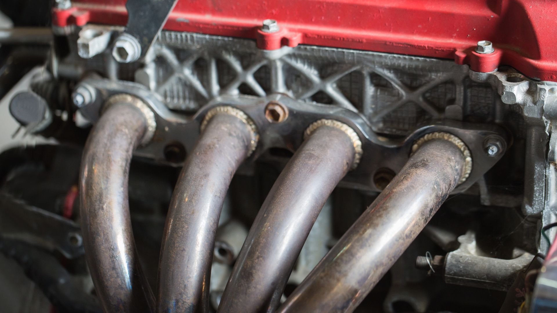 a close up of a red engine with four hoses.