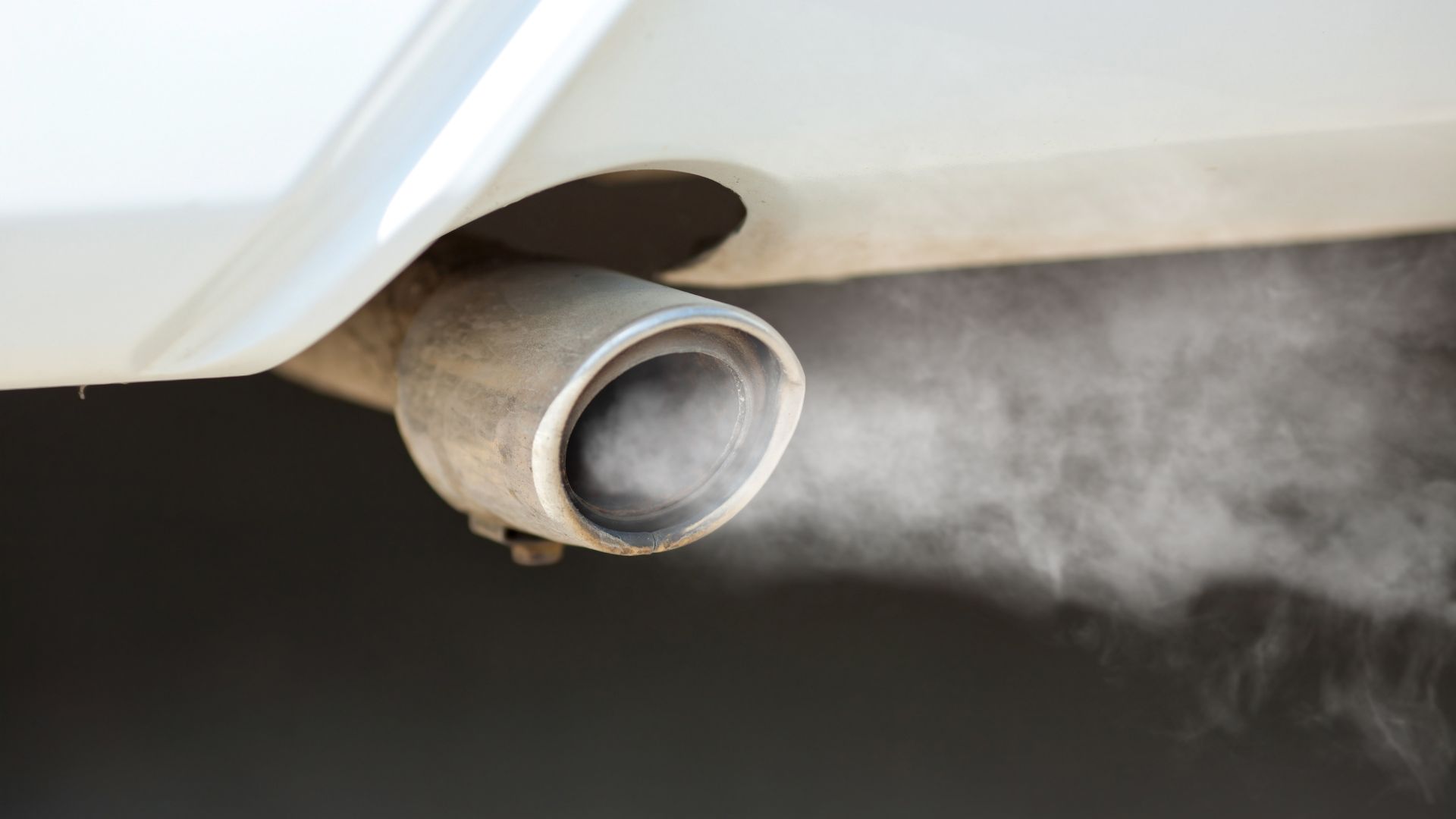 smoke coming out of the exhaust pipe of a car.