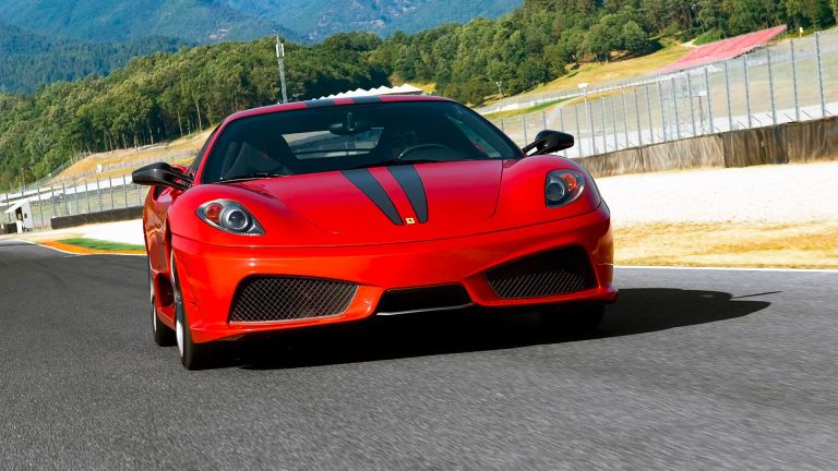 a red sports car driving down a race track.