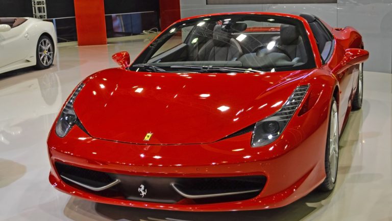 a red sports car is on display in a showroom.