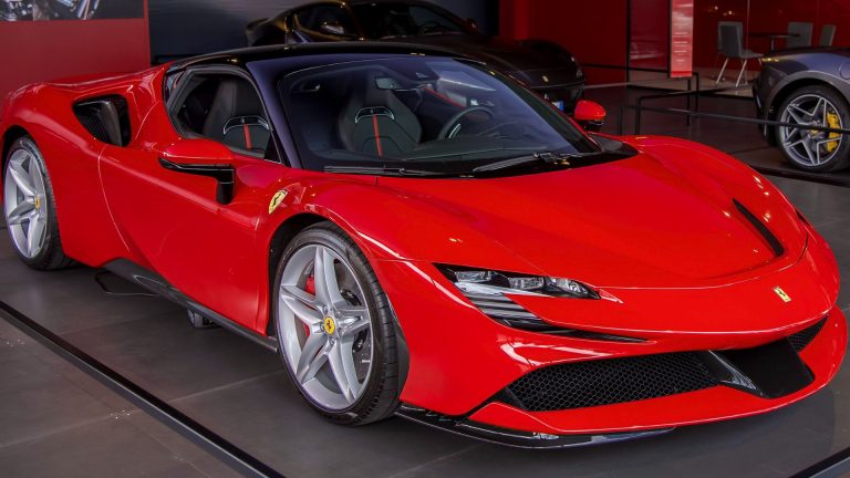 a red sports car on display in a showroom.