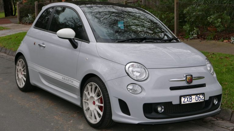 a small silver car parked on the side of the road.