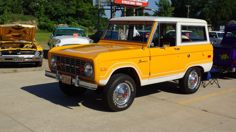 a yellow and white truck parked in a parking lot.