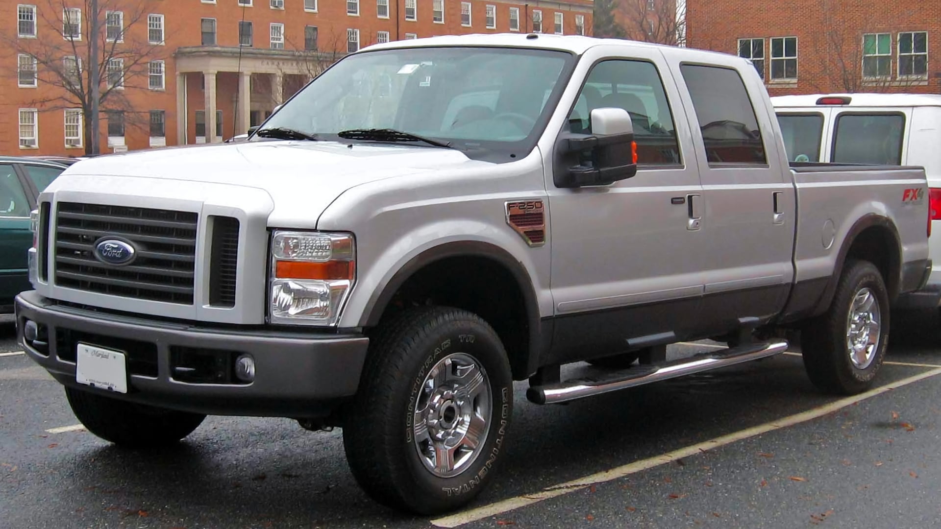 a silver truck is parked in a parking lot.