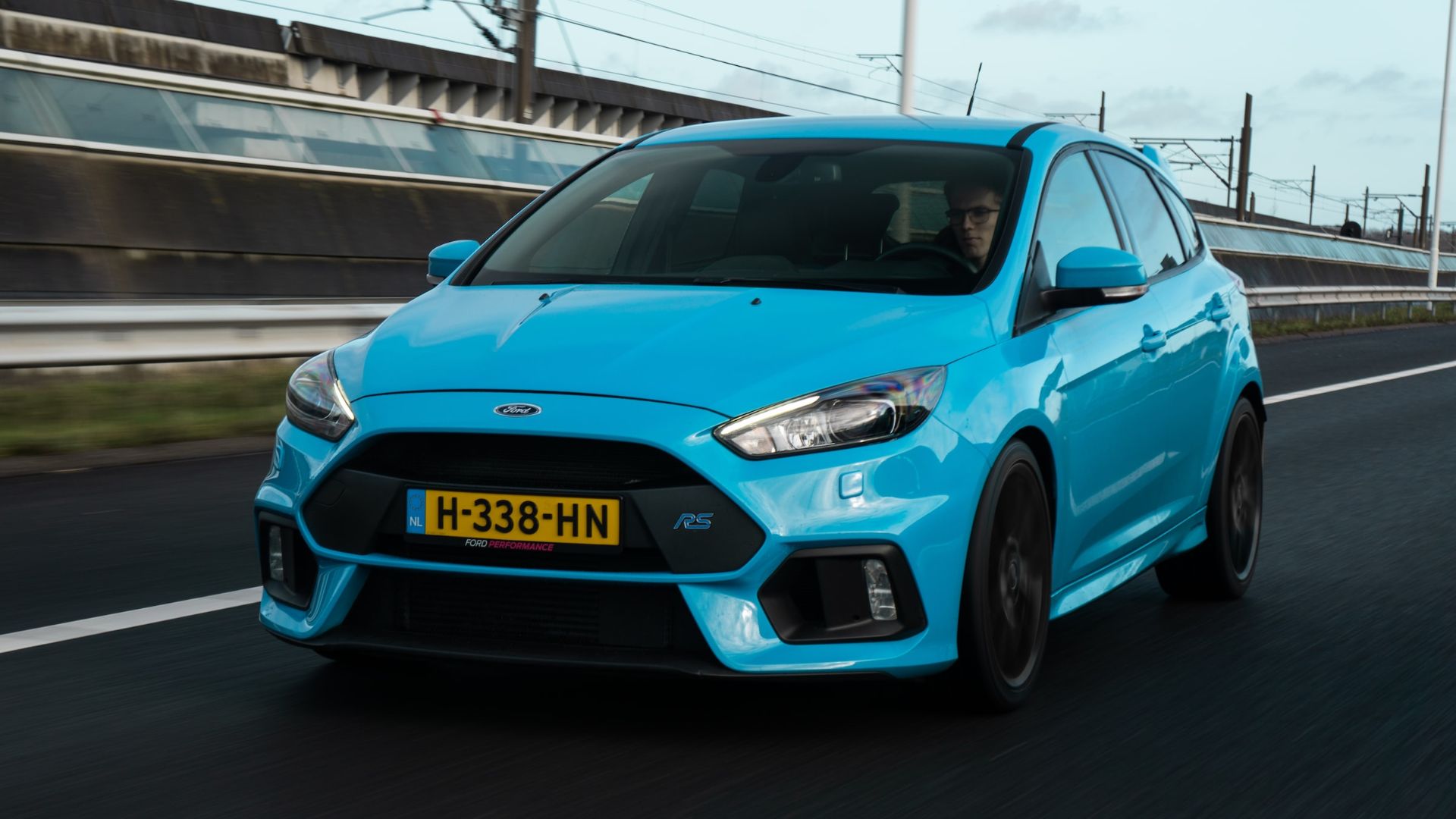 a blue ford focus st driving down a road.