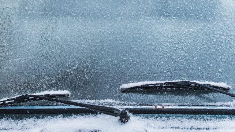 a couple of cars covered in snow next to each other.