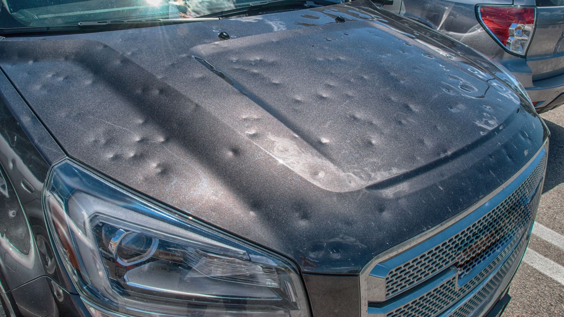 a close up of a car with a mattress on the hood.