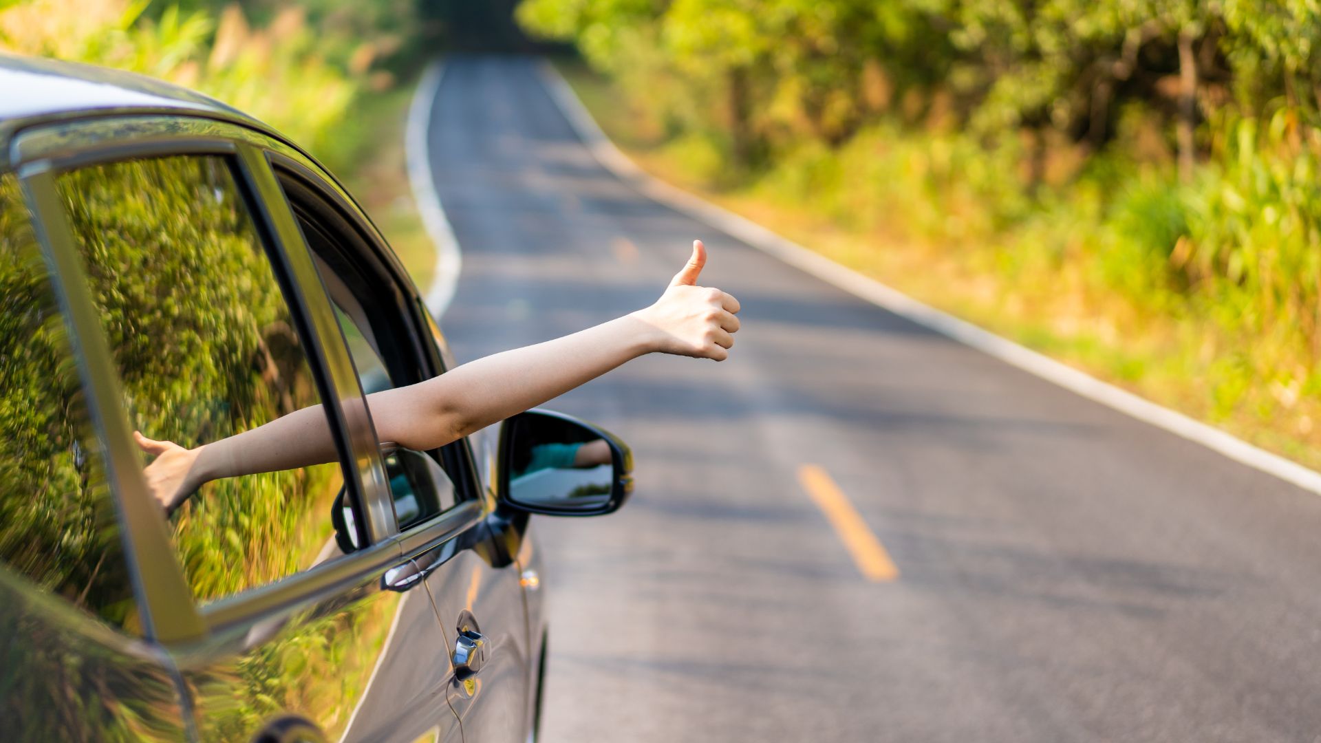 a woman's hand sticking out of a car window.