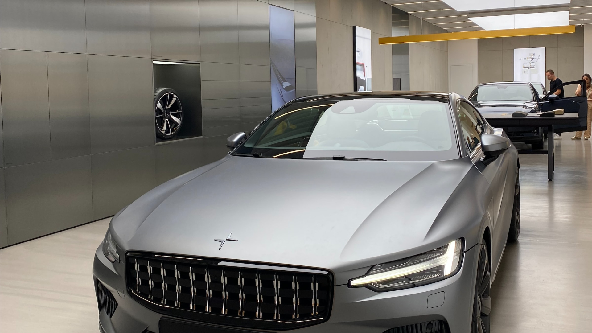 a silver car is parked in a showroom.