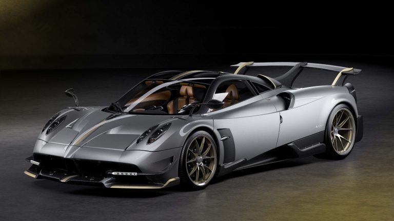 a silver sports car parked in a dark room.