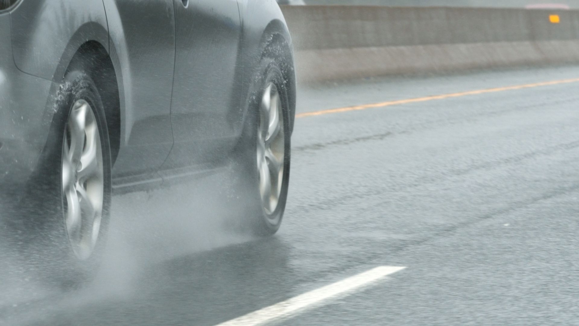 a car driving on a wet road in the rain.