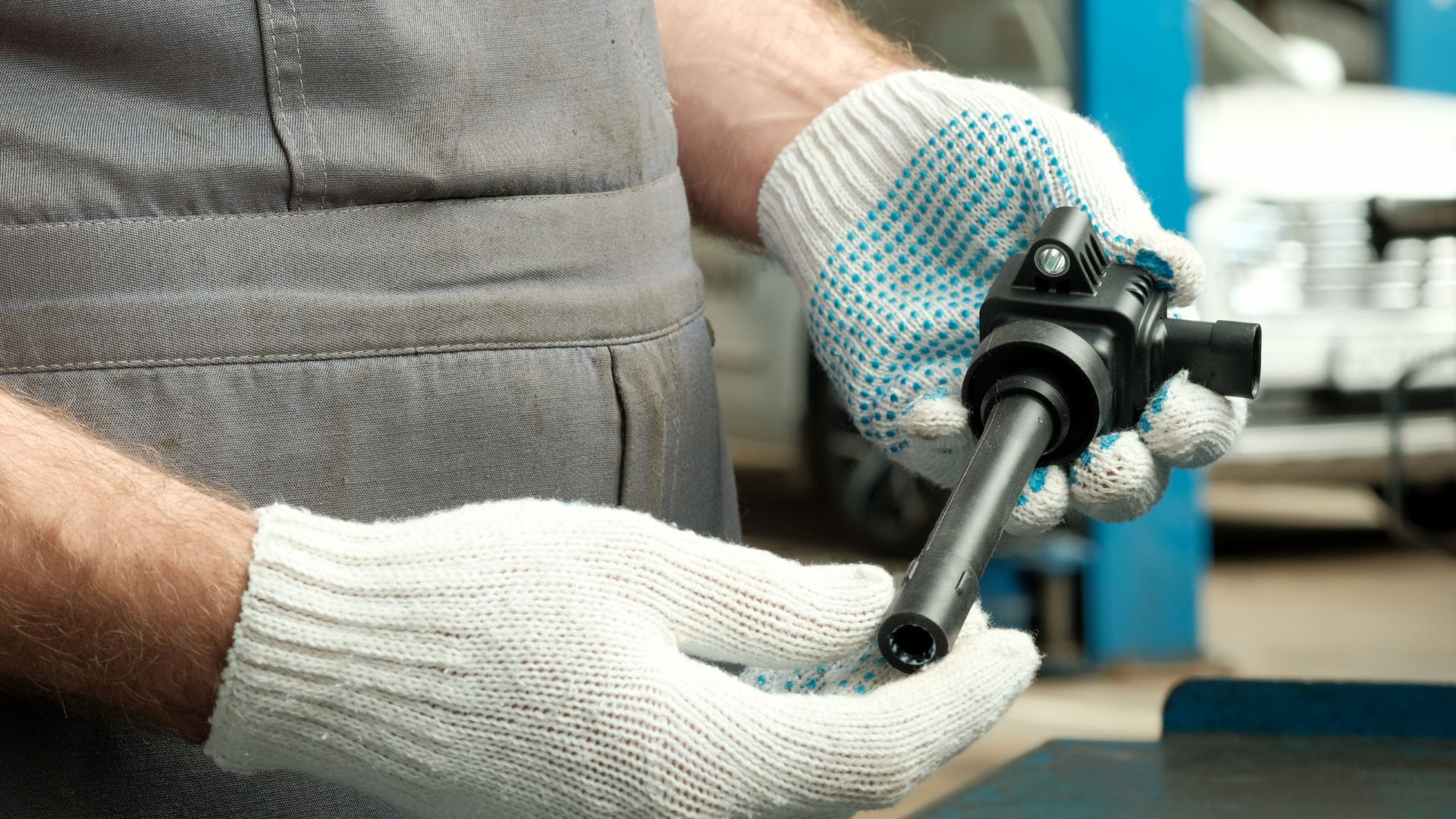 a man wearing gloves and holding a wrench.