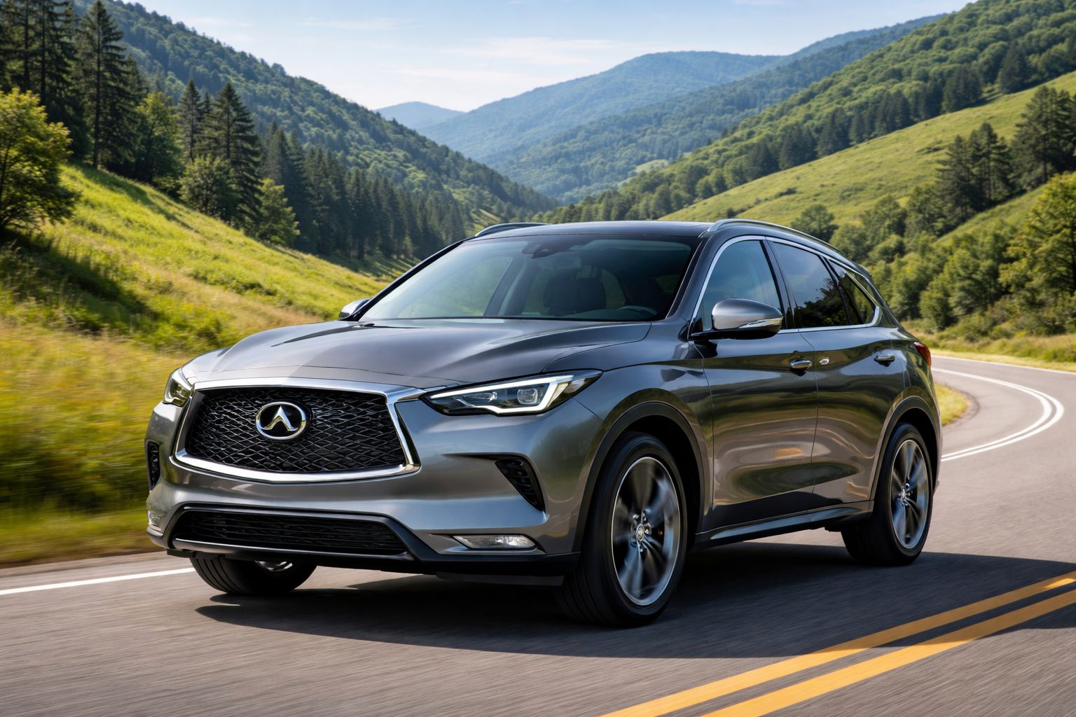 A silver Infiniti QX50 curves along a winding road through a lush, green mountainous landscape under a partly cloudy sky.