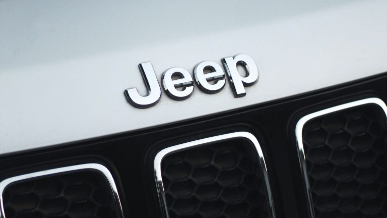 a jeep emblem on the front of a white car.