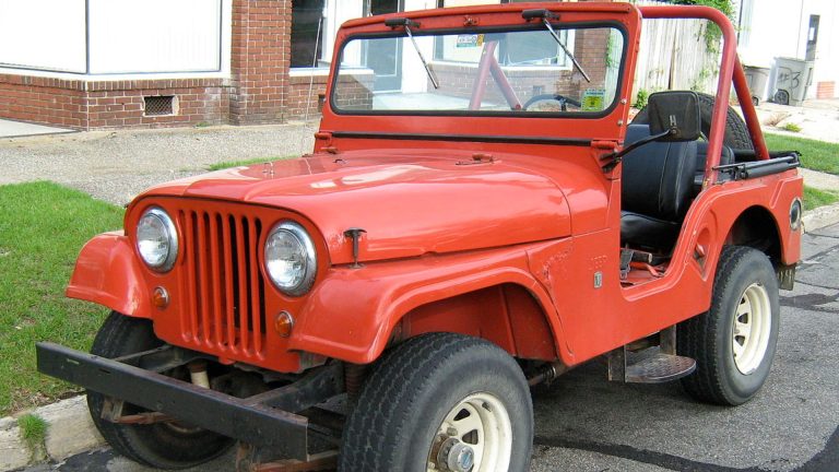 a red jeep parked on the side of the road.