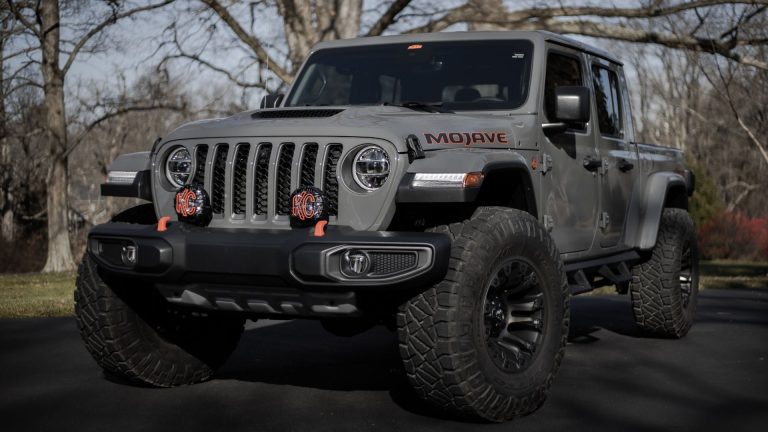 a gray jeep parked in a parking lot.