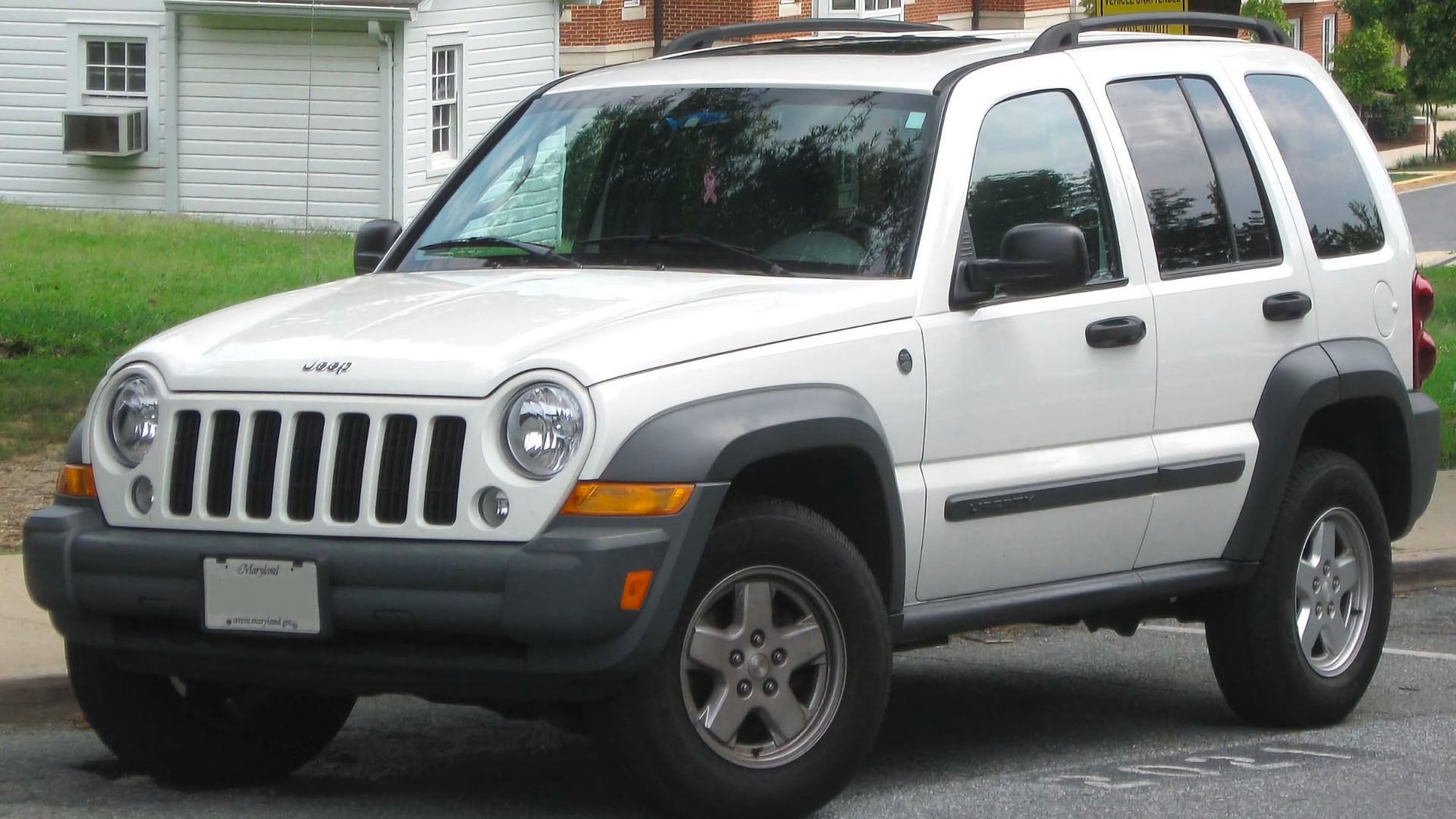 a white jeep parked on the side of the road.