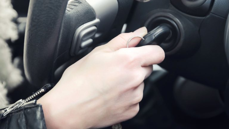a person holding a cell phone while driving a car.