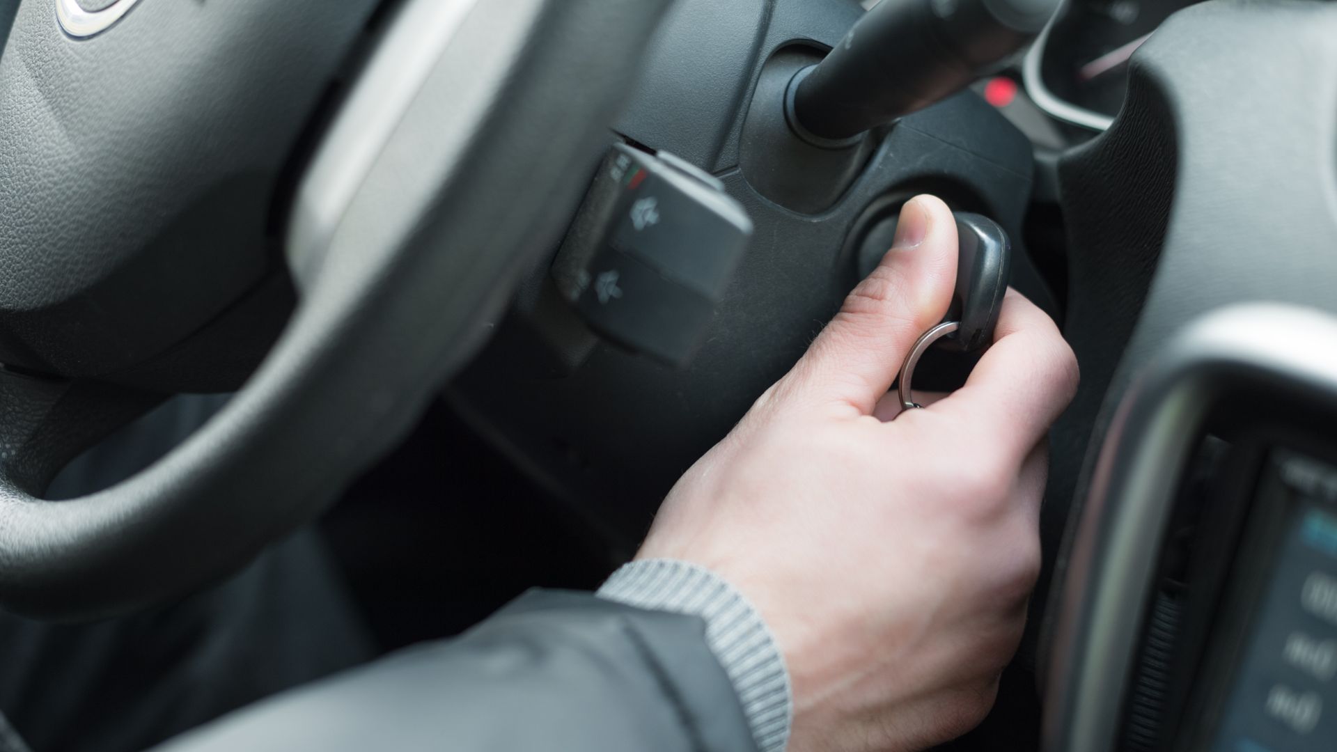 a person is holding the steering wheel of a car.