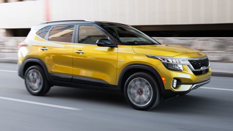 a yellow suv driving down a city street.