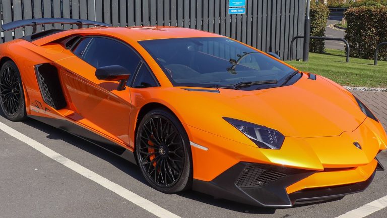 an orange sports car parked in a parking lot.