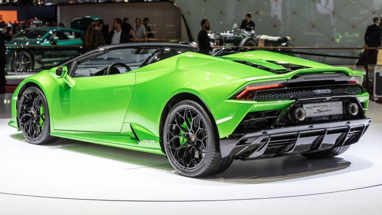 a green sports car on display at a car show.