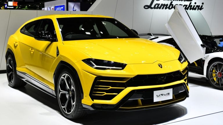 a yellow lamb suv is on display at an auto show.