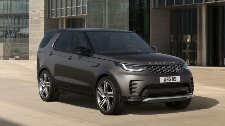 a grey range rover parked in front of a building.