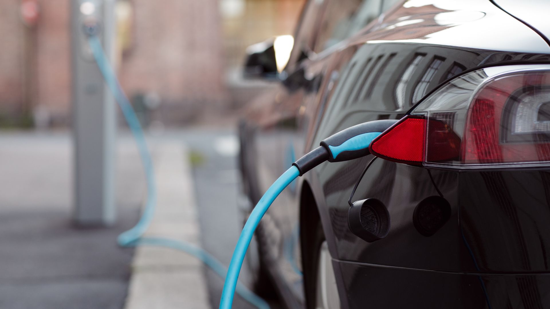 a black car with a blue hose attached to it.