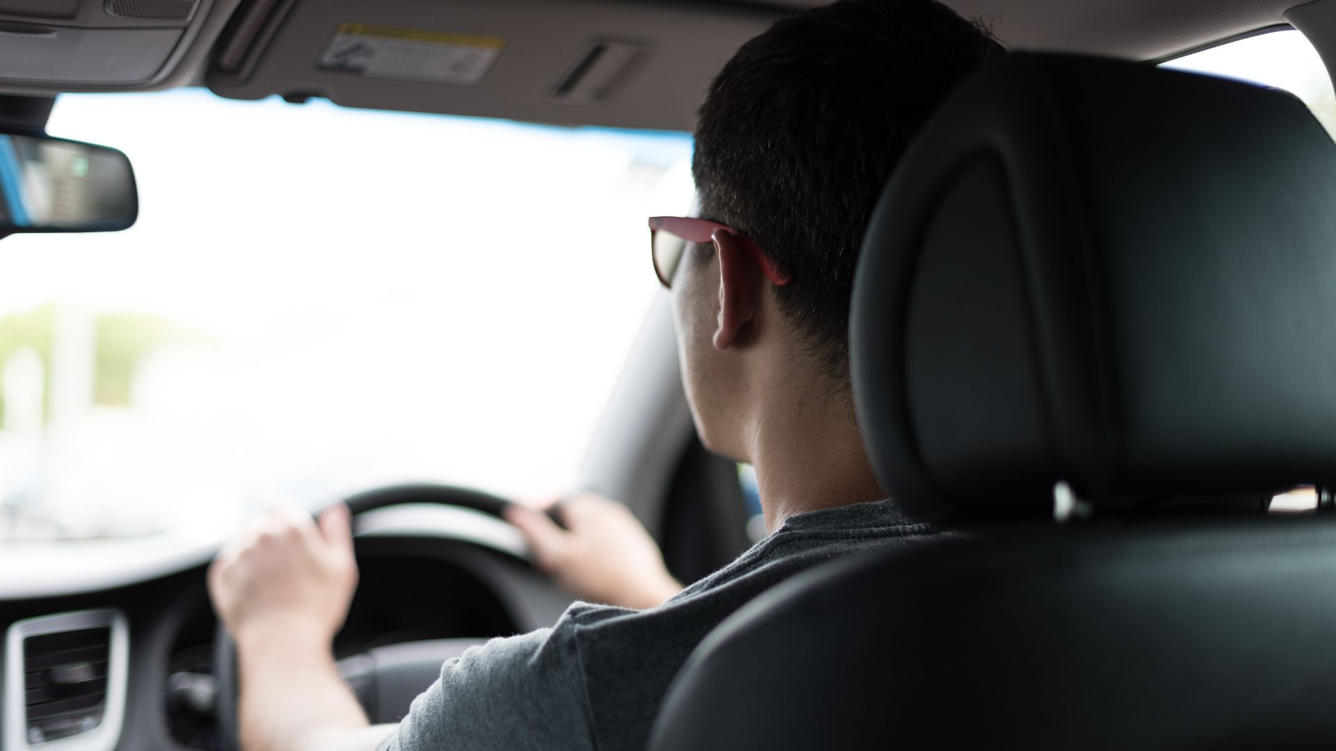 a man driving a car with his hands on the steering wheel.