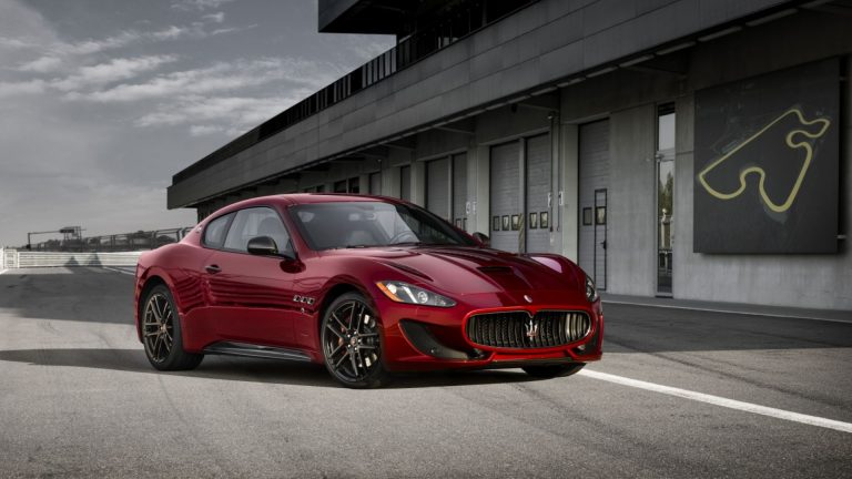 a red sports car parked in front of a building.