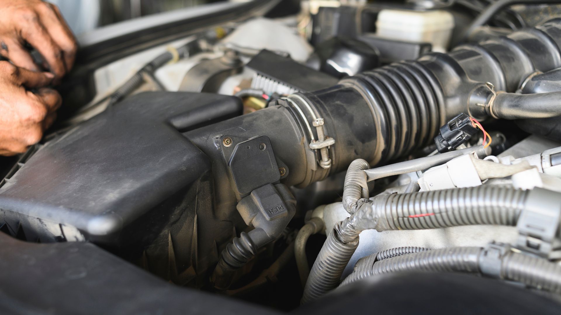 a close up of a person working on a car engine.